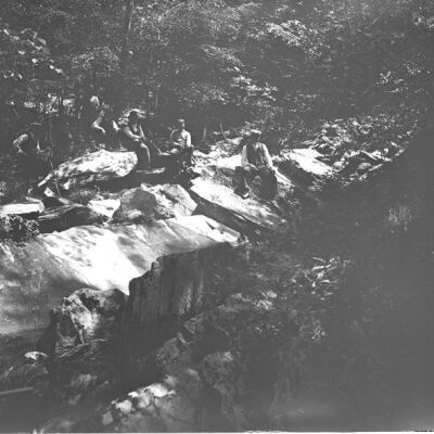 Men sitting on rocks near falls
