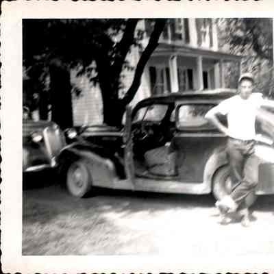 Two unidentified men next to a car