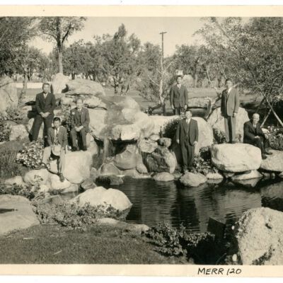 Photograph of seven men next to Pleasure Park pond at Manzanar