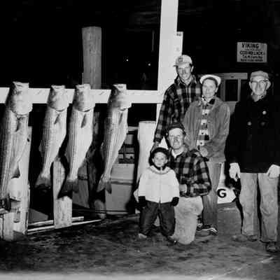 Potts family, posing with Striped bass on dock, circa mid- 1950s | Montauk Library Archives