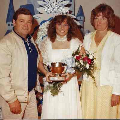 A color photograph of the 1983 Miss Brunswick Karen Coombs with her parents