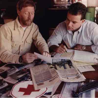 A photo view of two men at a table. 3/12/1990.