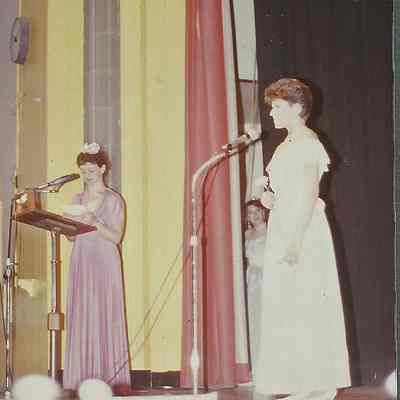 A color photograph of M. C. Sharon Hinckley asking Beth Wentworth the question.