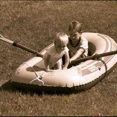 A photo view of 2 children playing in a boat. 11/1/1986.