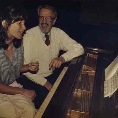 A photo view of 2 people sitting at a piano. 10/10/1988.