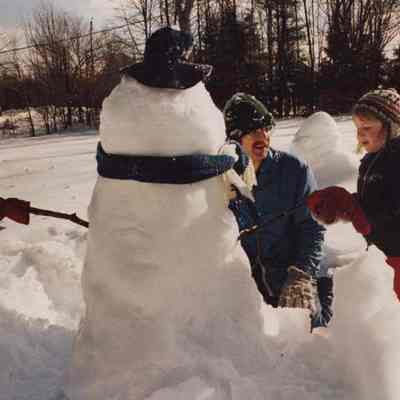 A photo view of father and daughter building a snowman. 1/26/1987.