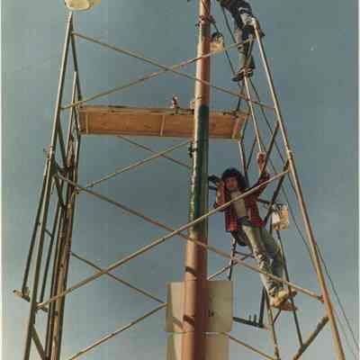 A photo view of two people painting a light pole. 6/13/1988.