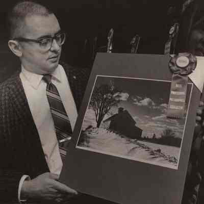 A photo view of Don Hinckley hold a photograph.