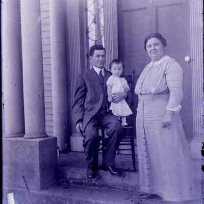 A couple standing holding a child.