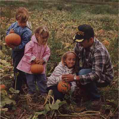 A photo view of some children getting pumpkins from a field. 9/22/1987.