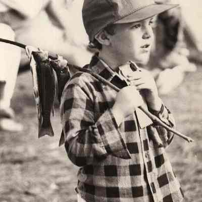 A photo view of a little boy carrying some fish. 6/8/1992.