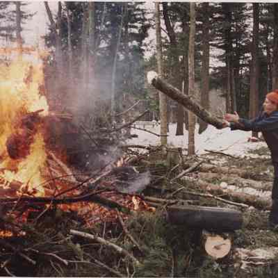 A photo view of a man burning brush. 1/8/1987.