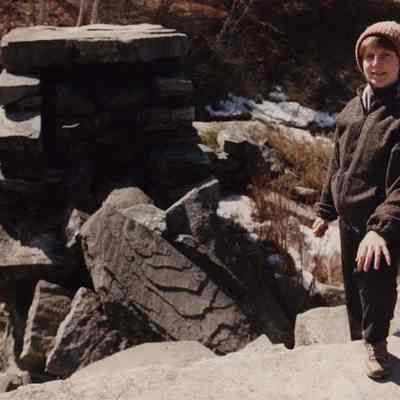A photo view of a woman by a fireplace. 3/29/1990