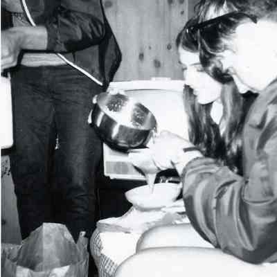 A B/W photograph of two young people having some thing to eat.