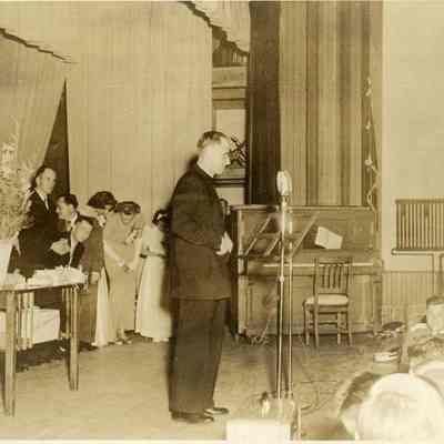 Father Dauphin at a Microphone