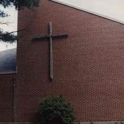 A photo view of a cross on the outside of a church. 6/15/1990.