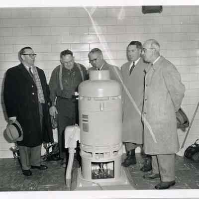 Men Standing Around Water Tank