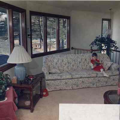 A photo view of a child sitting on a couch. 1/16/1989.
