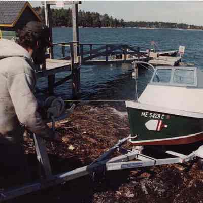 A photo view of a man putting his boat in the ocean. 5/19/1989.