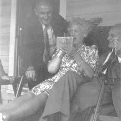 Three People Sitting on a Porch