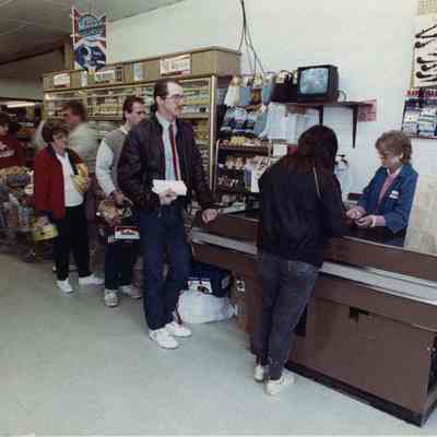A photo view of line at a check out counter. 4/30/1990.