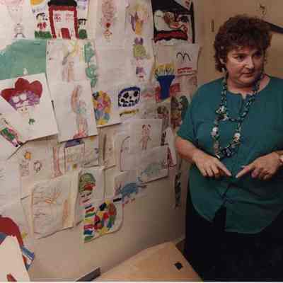 A photo view of a teacher (?) and some drawings. 7/27/1989.