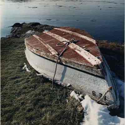 A photo view of a boat lying in the snow. 3/6/1990