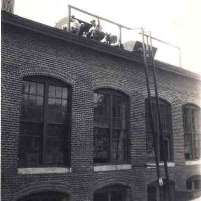 A photo view of workmen on the roof of the Pejepscot Mill.