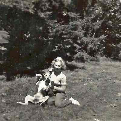 Unknown Woman Sitting on a Lawn with a Dog