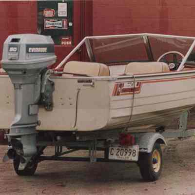 A photo view of a man pushing a boat and trailer. 4/20/1987.