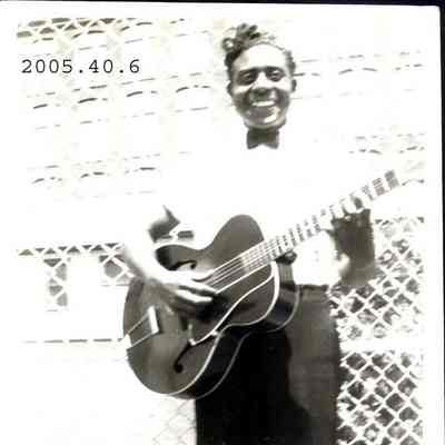 Photo of Reggie Garrison holding his guitar.
