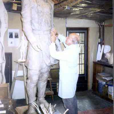 A color photograph of J. Query working on the Chamberlain statue.