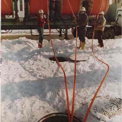A photo view of workmen installing fiber optic cable. 2/16/1988.