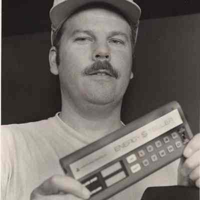 A photo view of a man holding an electronic devise. 10/7/1992.