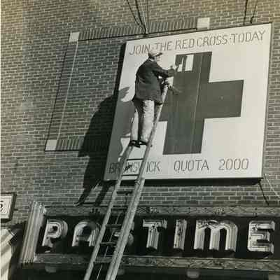 Man Painting a Red Cross Sign