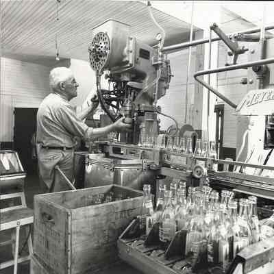Man Operating a Bottling Machine at the Pine Spring Water Company