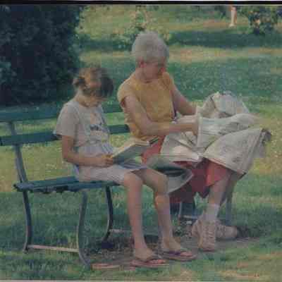 A photo view of 2 people sitting on a bench. 6/29/1988.