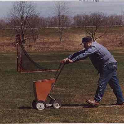 A photo view of a man marking lines on a soccer field. 4/15/1988.