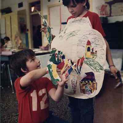 A photo view of two children making finger puppets. 4/17/1989.