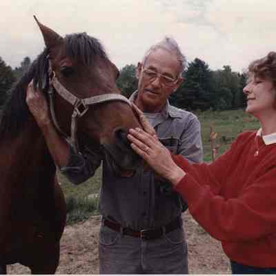A photo view of two people petting a horse. 6/13/1988.