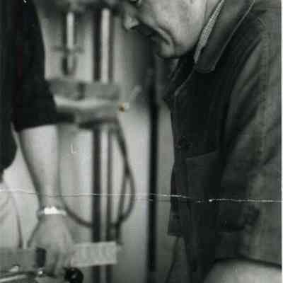 A photo of Robert Wescott sawing wood. c. 1962