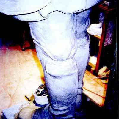 A color photograph of the JLC statue showing a side view of the feet.