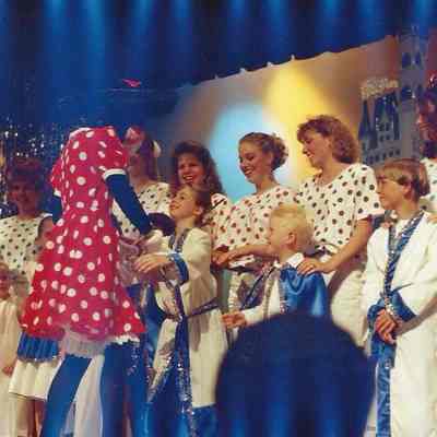 Mini Mouse shaking hands with small people.