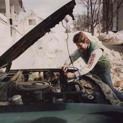 A photo view of a man jump starting his car. 2/5/1987