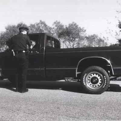 A photo view of a police officer stopping a truck. 9/10/1992.