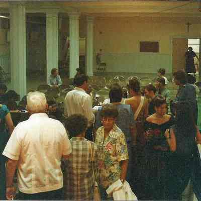 A color photograph of people waiting to get some food.