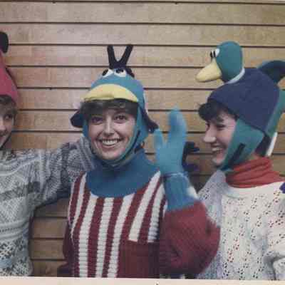 A photo view of three women with funny hats. 12/13/1991