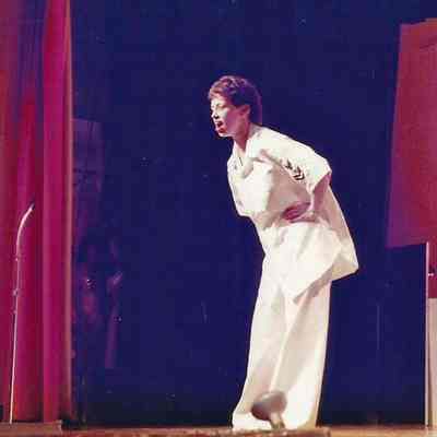 A color photograph of Sharon singing.