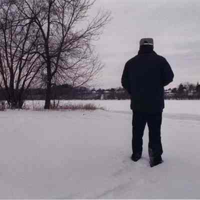 A photo view of a man looking at a snow covered river. 1/15/1991.