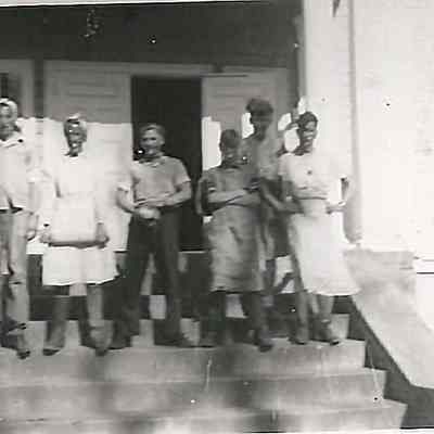 Six Undentified People Standing on a Door Step